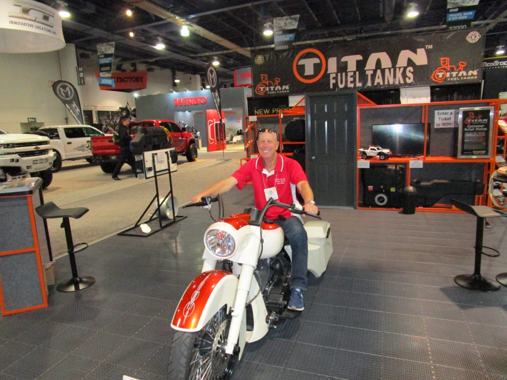 Adam Scheps sitting on a White and Red Motorcycle